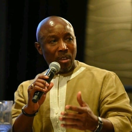 Magnus Conteh speaking into a microphone